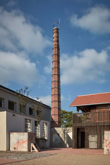 Hlavní dominantou areálu, patrnou z velké dálky, je tovární komín. 