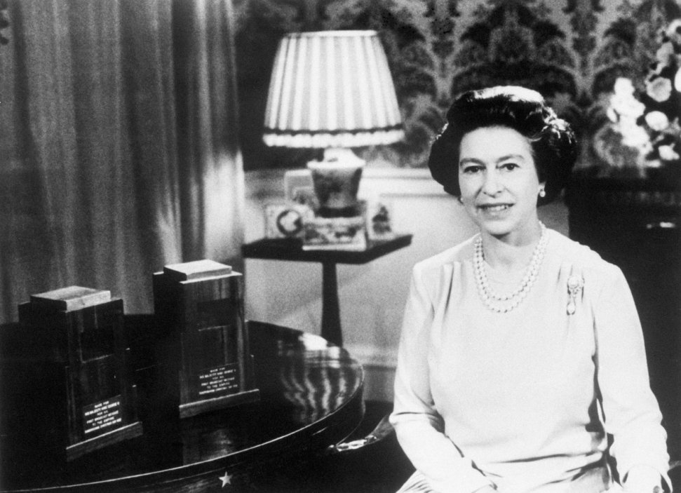 Královna Alžběta II. při natáčení jejího tradičního vánočního proslovu v Regency Room v roce 1978. Na stole stojí originální mikrofony, které poprvé použil král Jiří V. pro první vysílání štědrovečerního projevu v roce 1932.