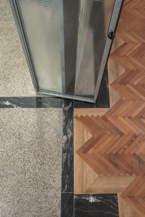Spáry v podlaze po vybouraných příčkách tak byly nahrazeny kamennými pásy a následně přebroušeny společně s terrazzem. 