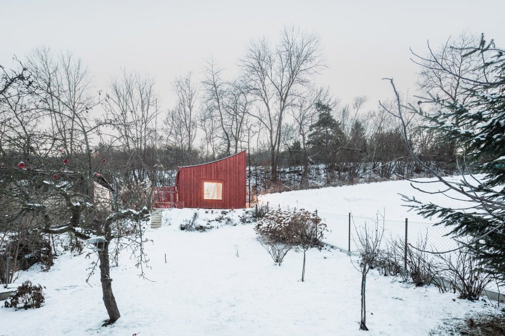 Dům - plot stojí na konci úvozové cesty, na úzkém a svažitém pozemku, na rozhraní města a krajiny, popisují architekti ze studia Byró